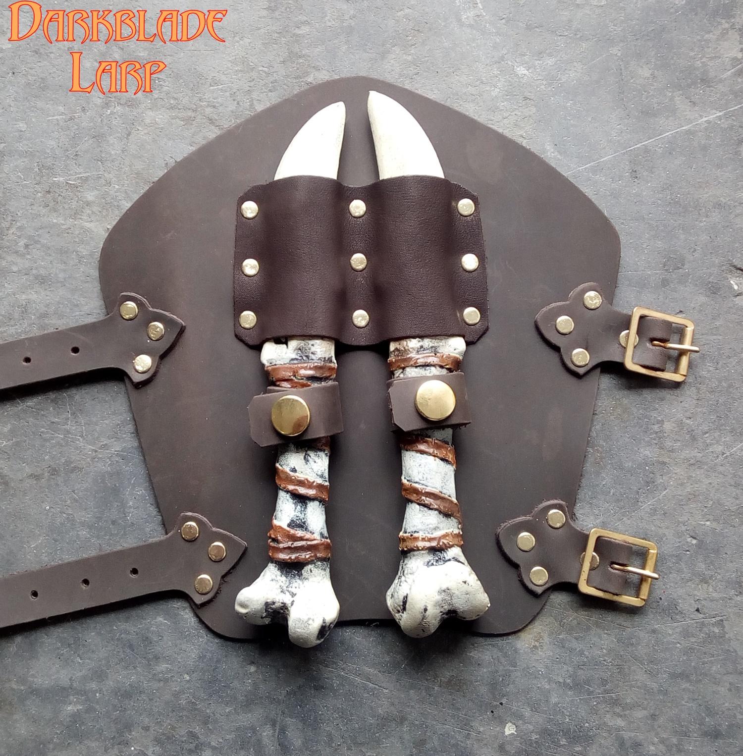 A vambrace with two bone throwing knives cliped on to the front