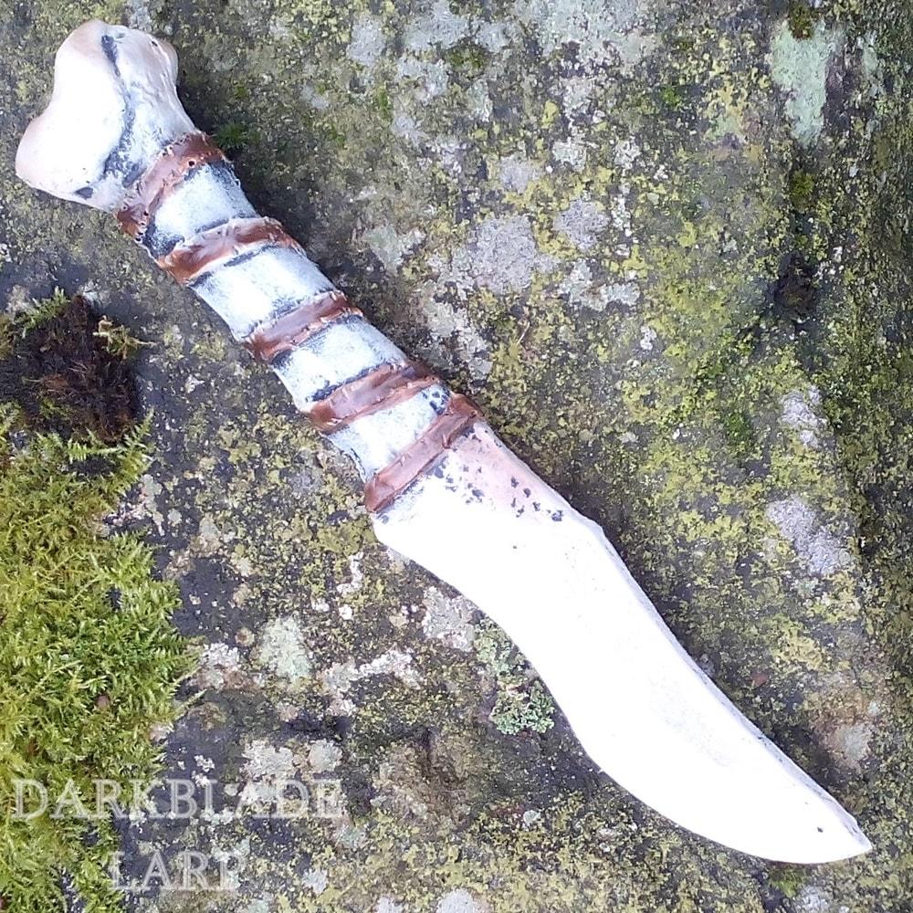 A throwing knife that looks like it is made of bone