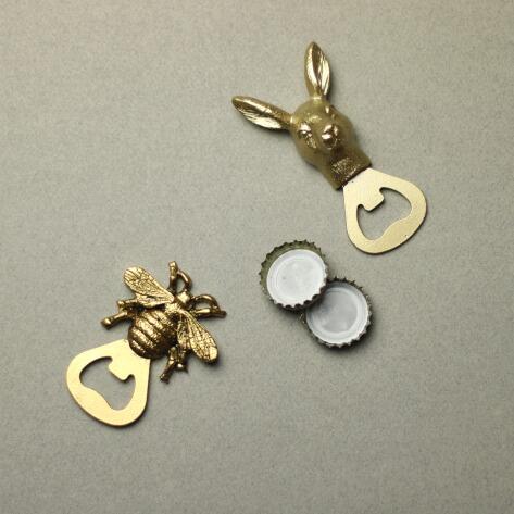 two gold bottle openers with two bottle tops