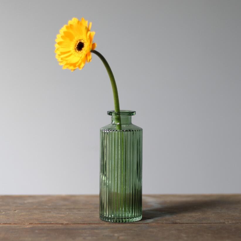 Small ribbed vintage green bottle bud vase with single stem