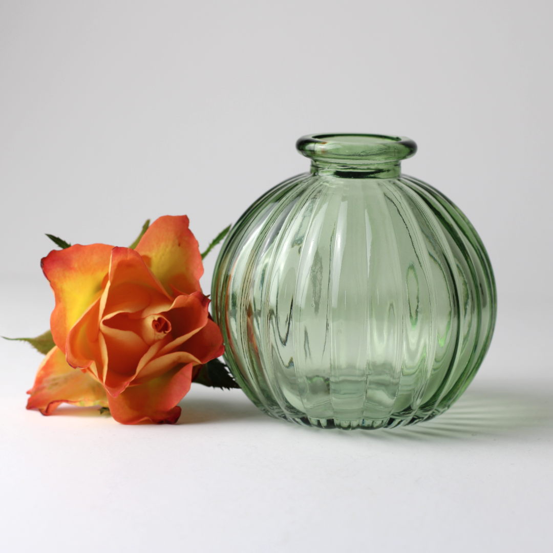 vintage inspired green glass vase next to a single bloom