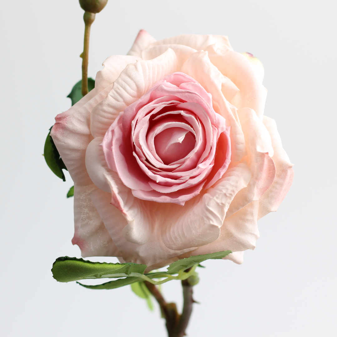 close-up of an artificial pink rose bloom, showing the intricate details of the realistic petals.