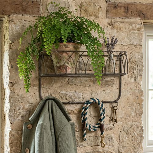 rustic coat rack with basket shelf displaying a vintage pot