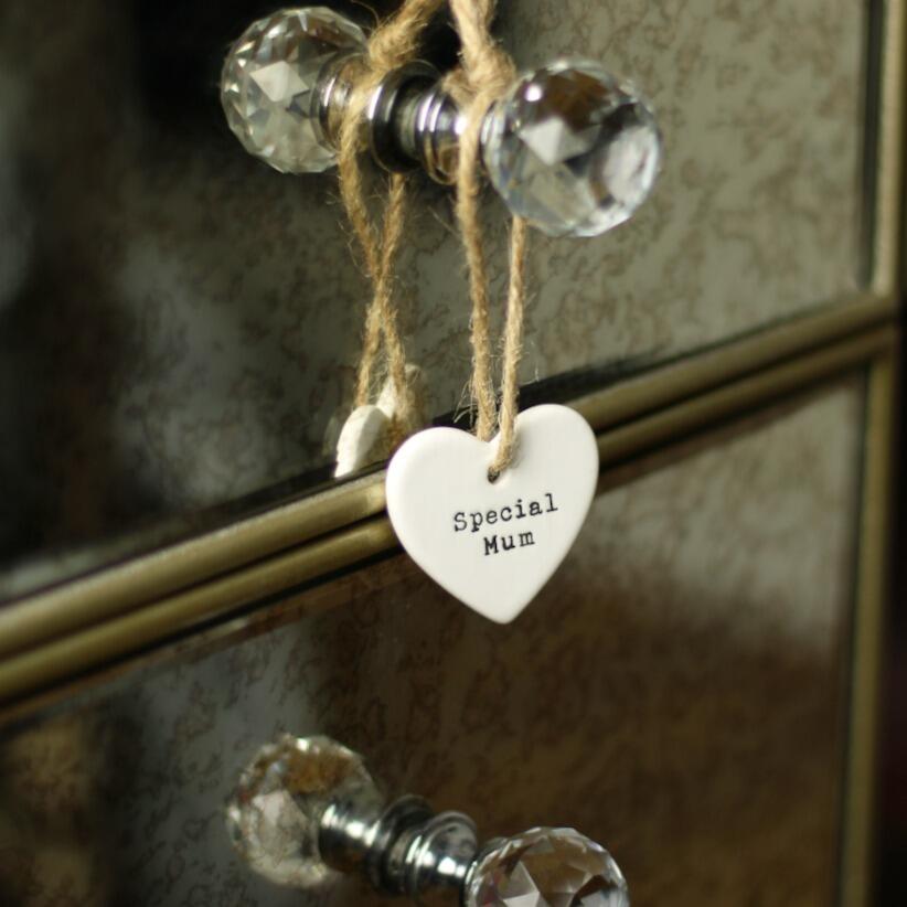 White ceramic heart shaped hanging decoration with the words special mum elegantly written on it hanging from dressing table