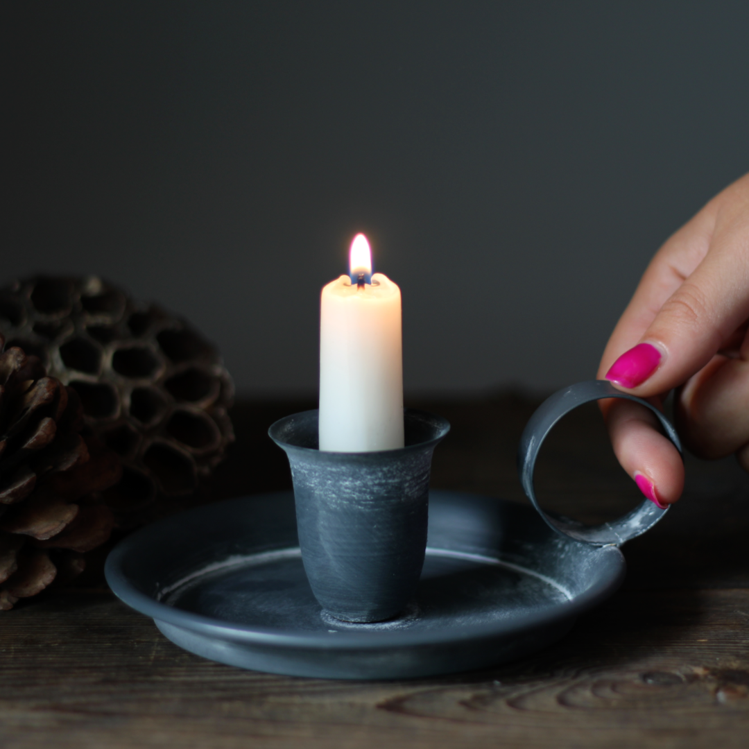 dark grey metal chamberstick candle holder with a distressed finish