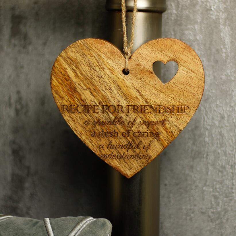 wooden hanging heart, adorned with the heartfelt words "Recipe for Happiness: A spoonful of kindness, a large smile, lots of hugs" hanging from bedpost