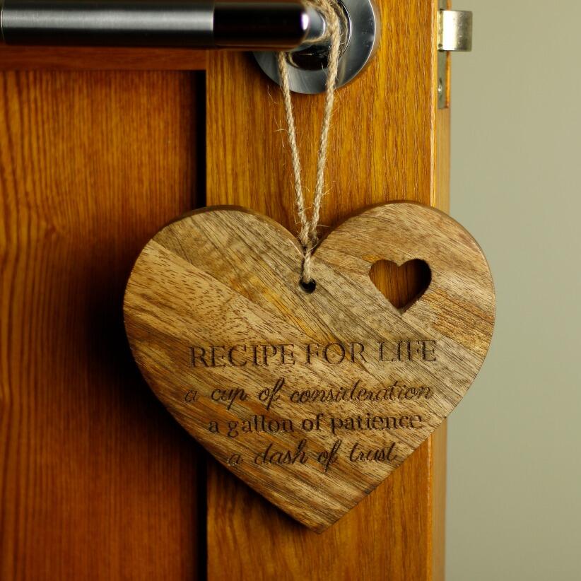 wooden hanging heart, adorned with the heartfelt words "Recipe for Life: A cup of consideration, a gallon of patience, a dash of trust."  hanging from door handle