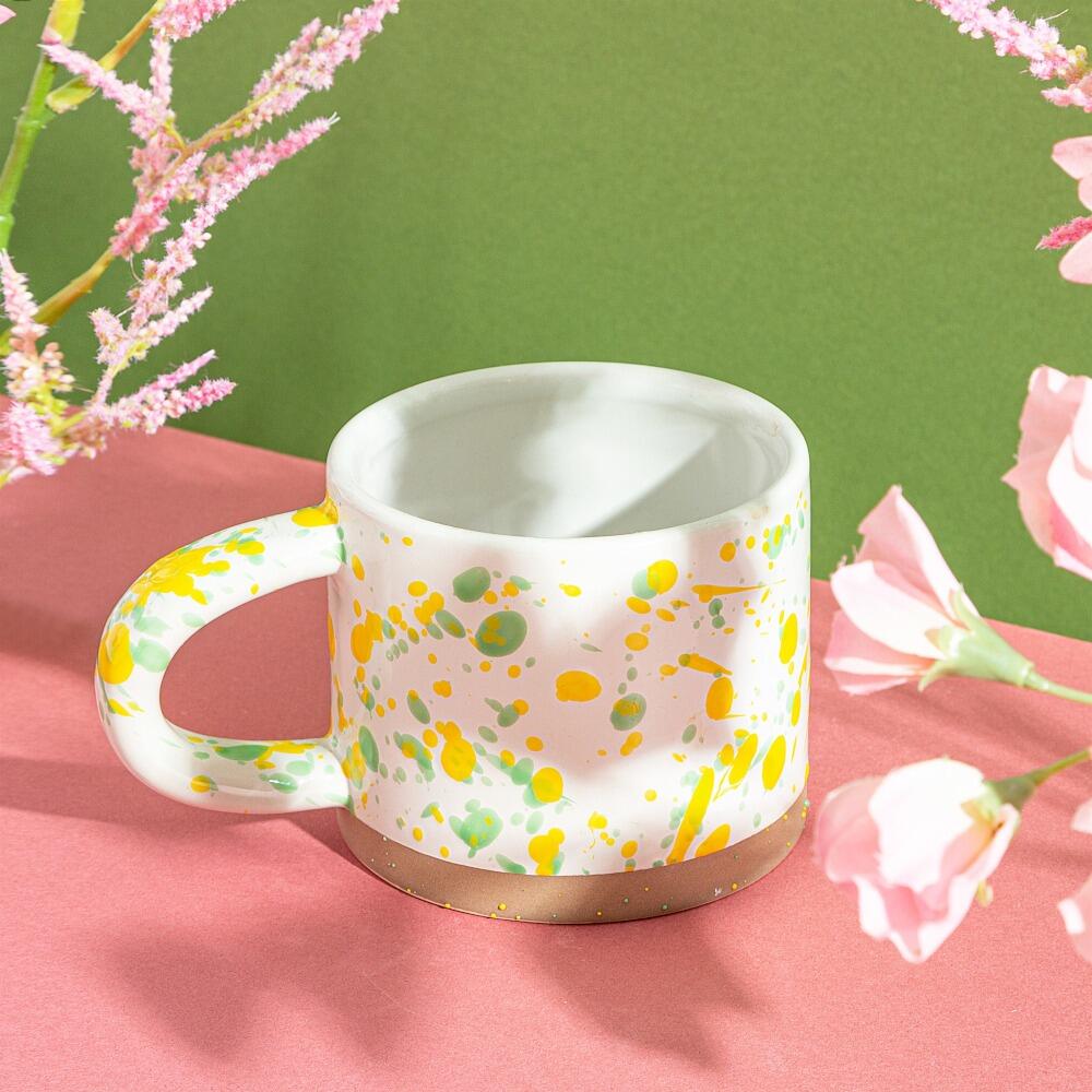 Yellow and green splatter mug lifestyle picture front