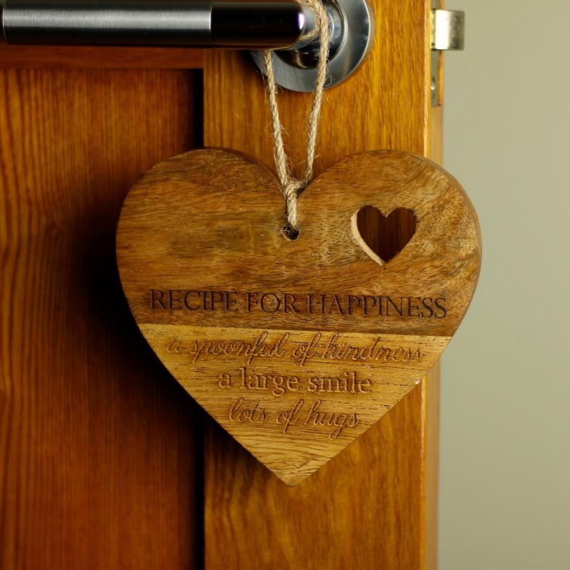 wooden hanging heart, adorned with the heartfelt words "Recipe for Happiness: A spoonful of kindness, a large smile, lots of hugs" hanging from door handle