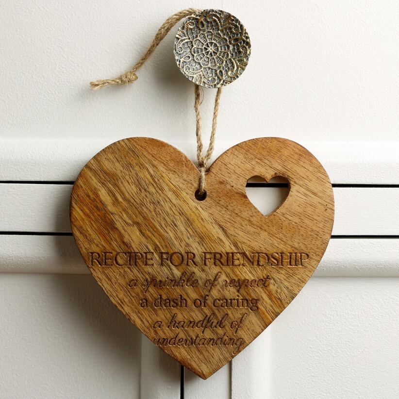 Large wooden hanging love heart with the words "Recipe for Friendship: A sprinkle of respect, a dash of caring, a handful of understanding." hanging from draw handle