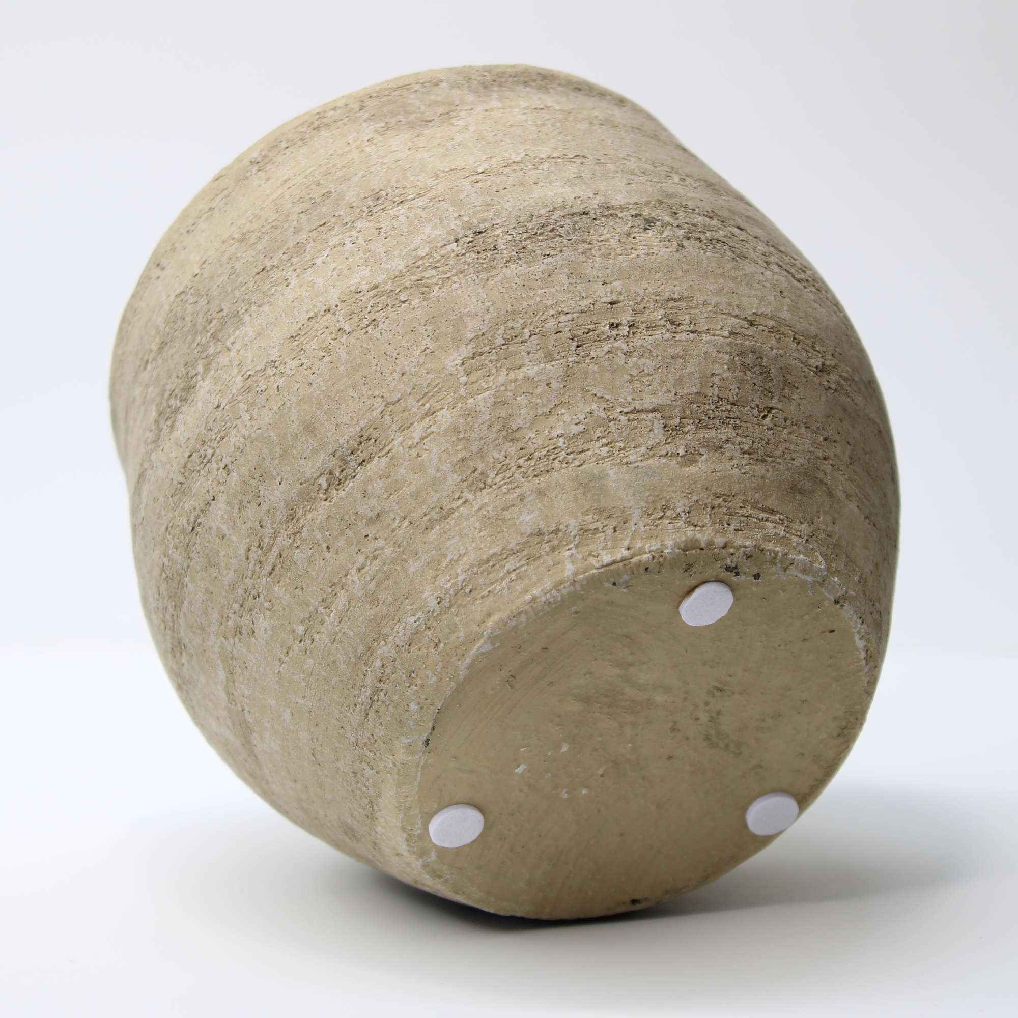 aged distressed indoor plant pot on its right side, showing the rubber pads on the base