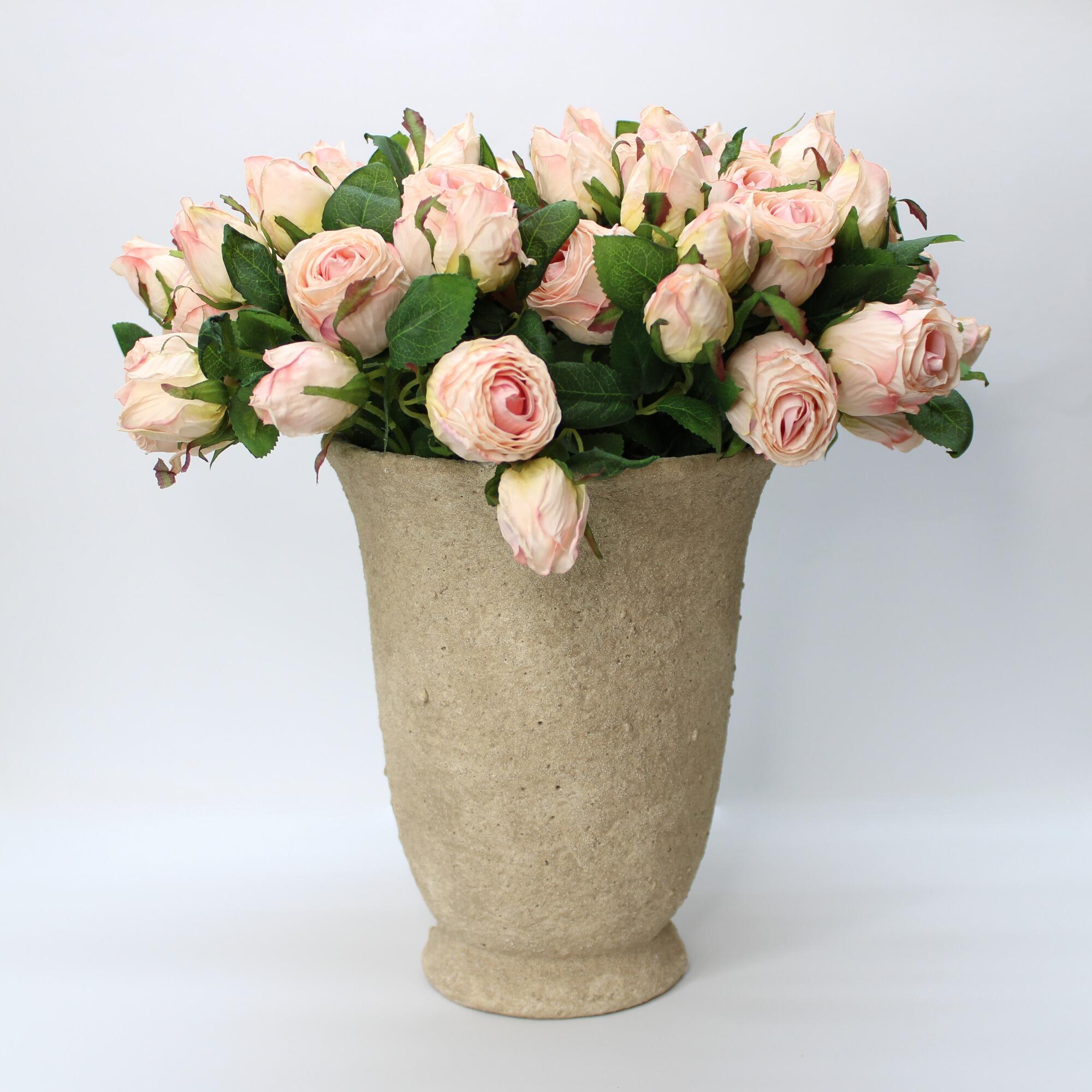 Distressed cement urn pot displaying a bunch of pink roses.