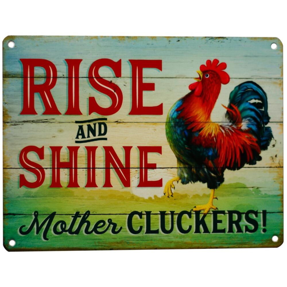 A funny retro metal sign displaying the words "Rise and Shine Mother Cluckers" in bold lettering against a plain background.