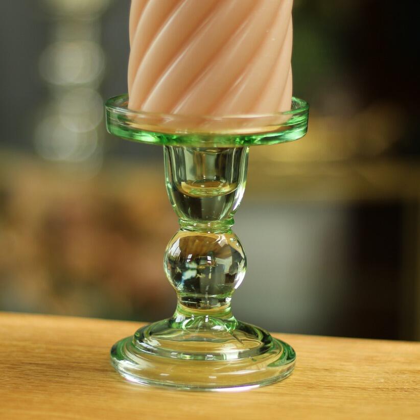 small green glass candlestick with pillar candle
