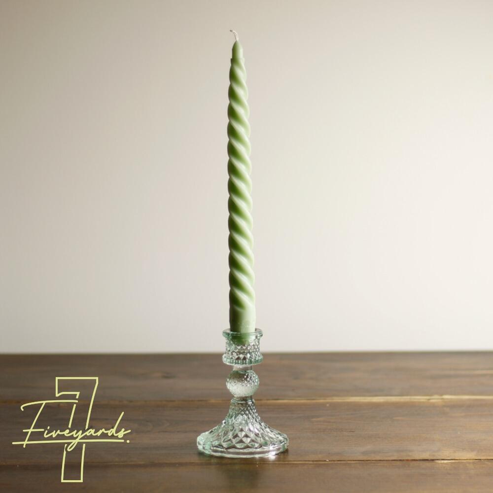 Short cut glass candle holder with green twist dinner candle