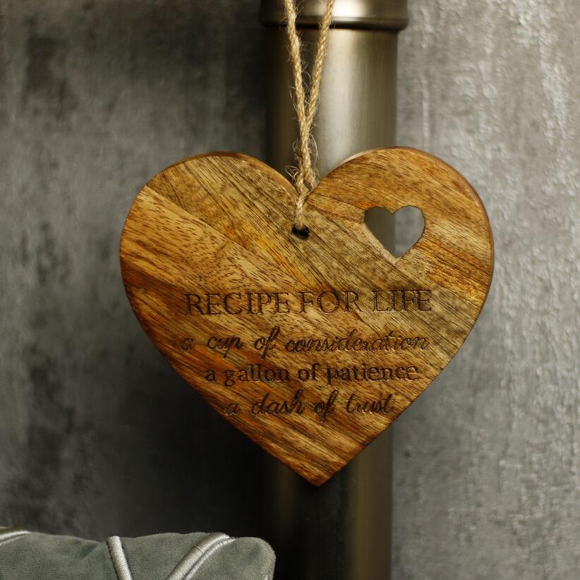 wooden hanging heart, adorned with the heartfelt words "Recipe for Life: A cup of consideration, a gallon of patience, a dash of trust."  hanging from bedpost