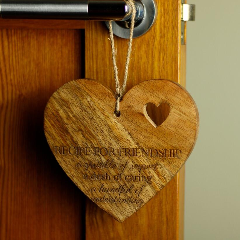 Large wooden hanging love heart with the words "Recipe for Friendship: A sprinkle of respect, a dash of caring, a handful of understanding." hanging from door handle
