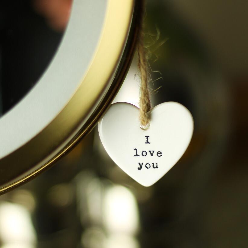 I love you dainty white ceramic hanging heart hanging from makeup mirror