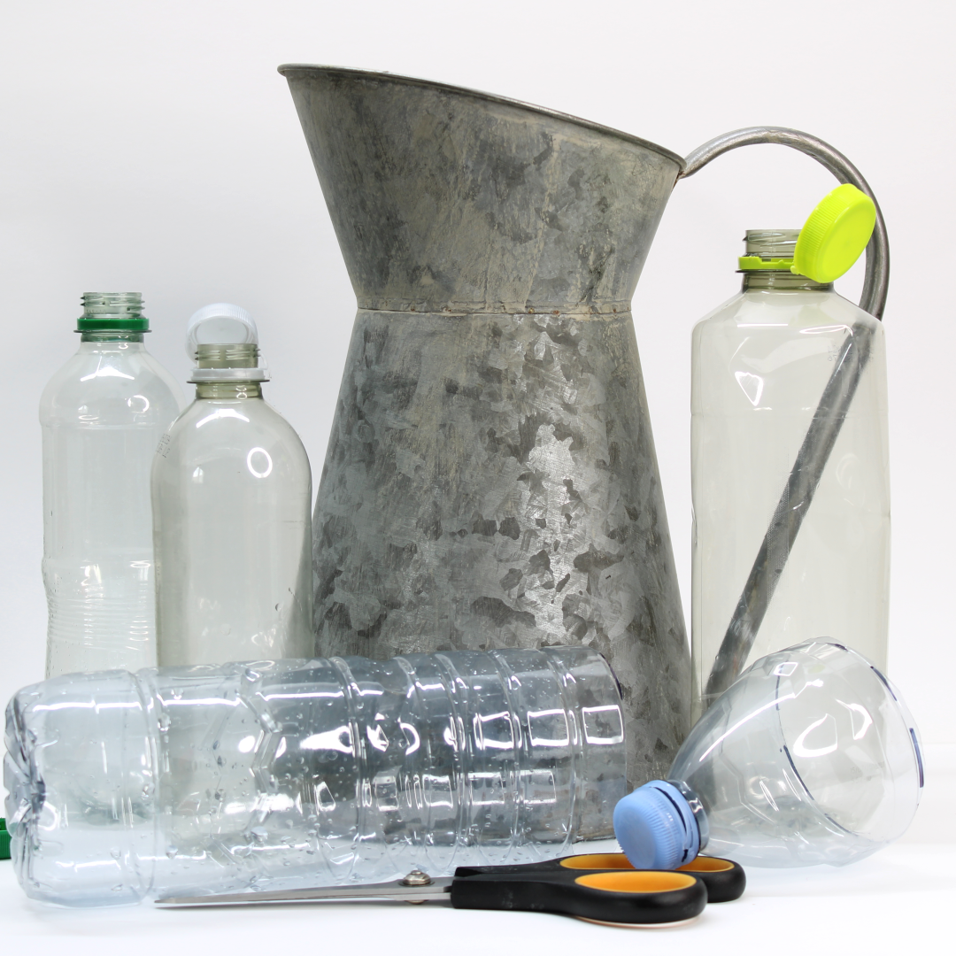 Selection of repurposed plastic bottles utilised as waterproof pot inserts, positioned alongside a decorative jug in a vintage style.