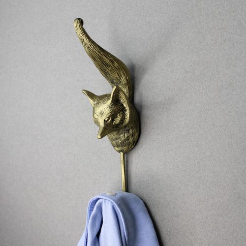 Gold vintage fox wall hook holding a blue shirt