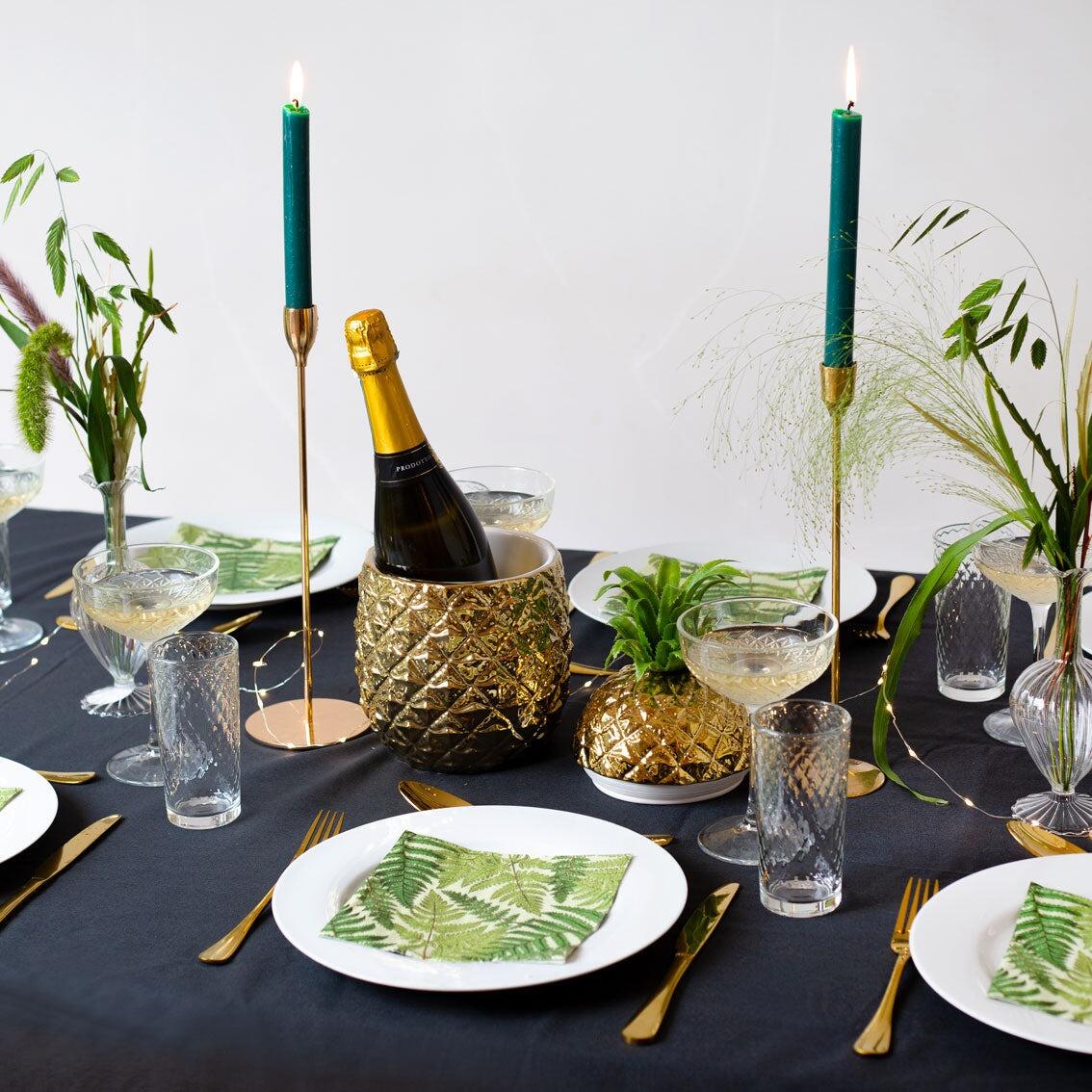 gold pineapple ice bucket on a dinner table used as a champagne cooler