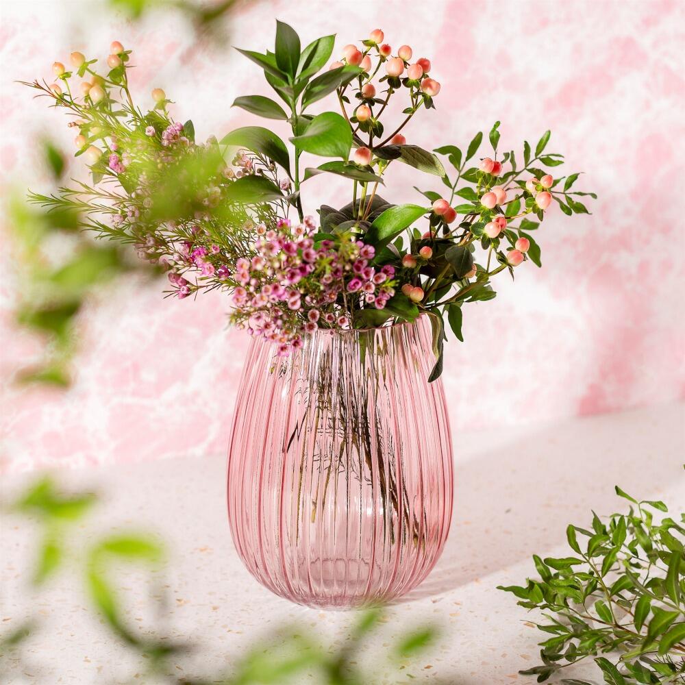 Elegant fluted glass vase in pink with small bunch of fresh flowers