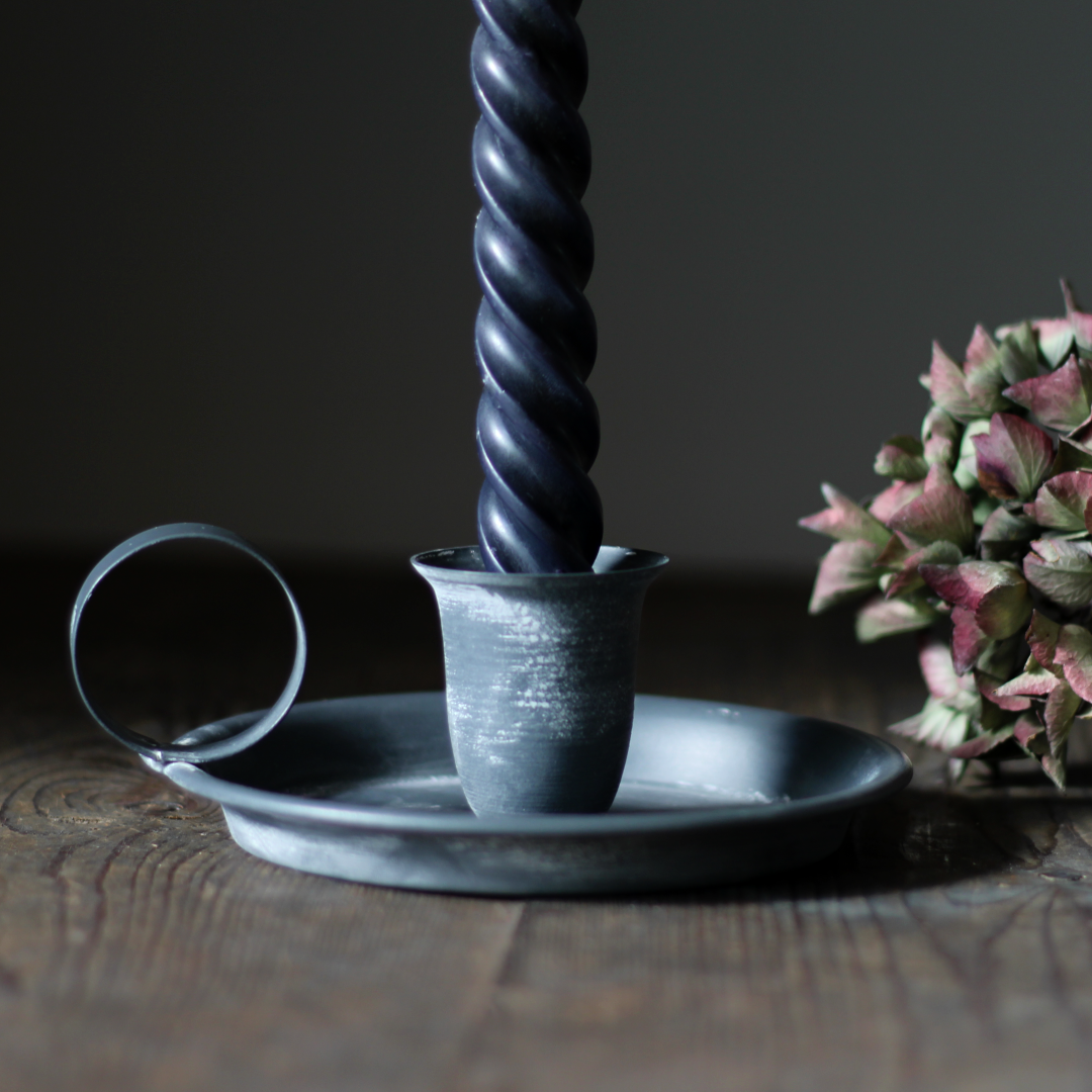 rustic metal chamberstick with a black twisted taper candle