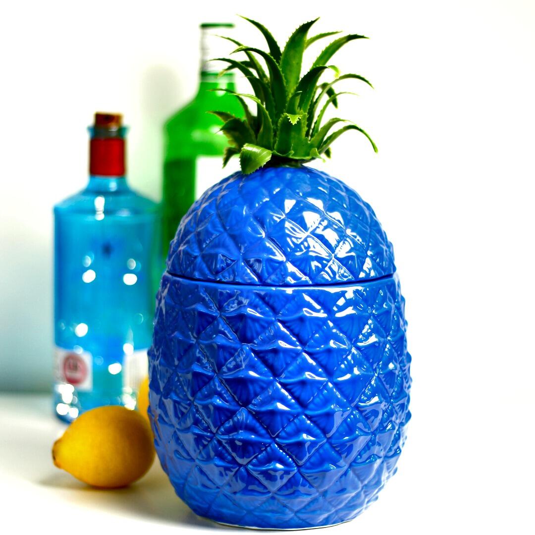 Blue pineapple ice bucket with lemon and bottle in the background