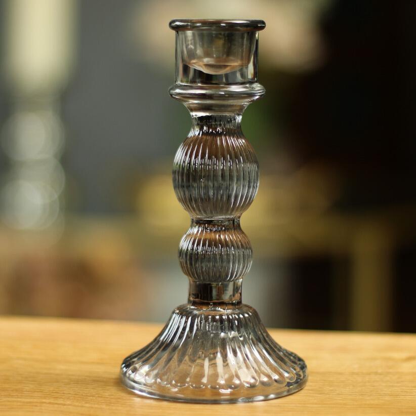 small smokey grey glass candle holder on wooden table top