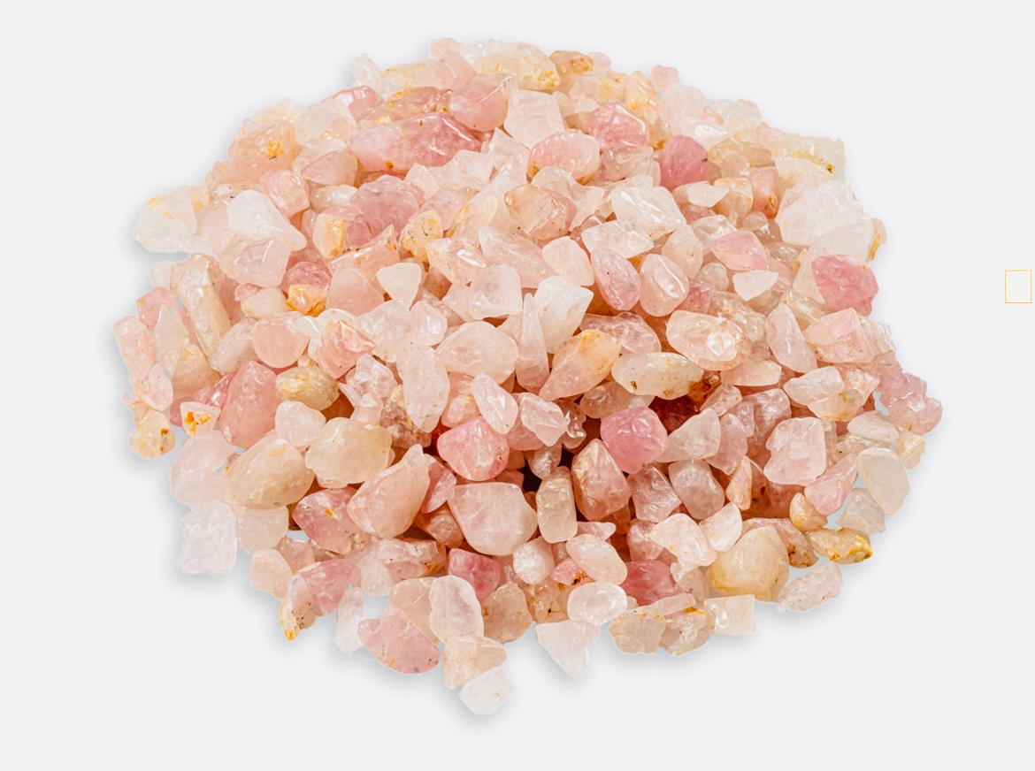Oile of Rose Quartz crystal chips on a table