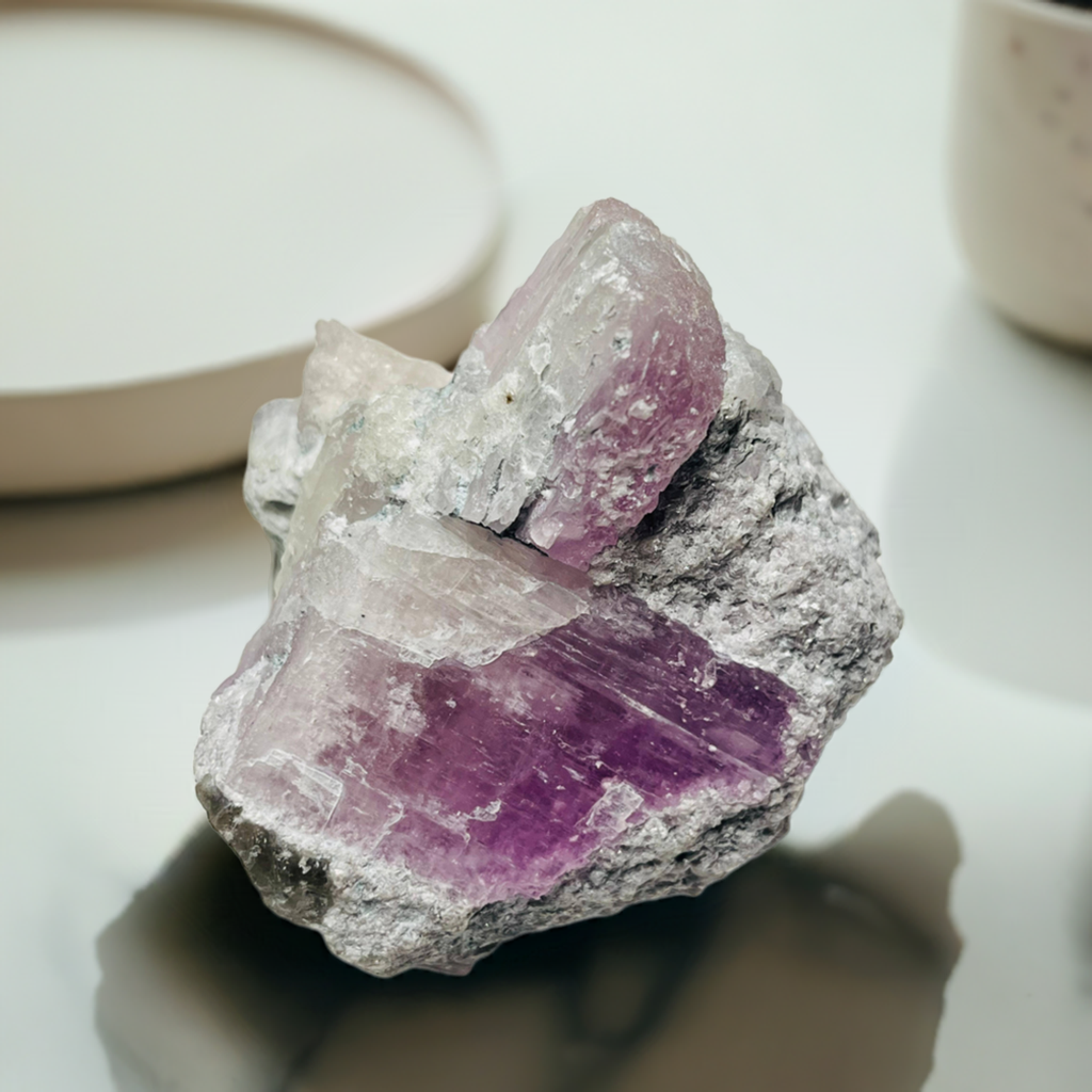 kunzite raw specimen on a marble table