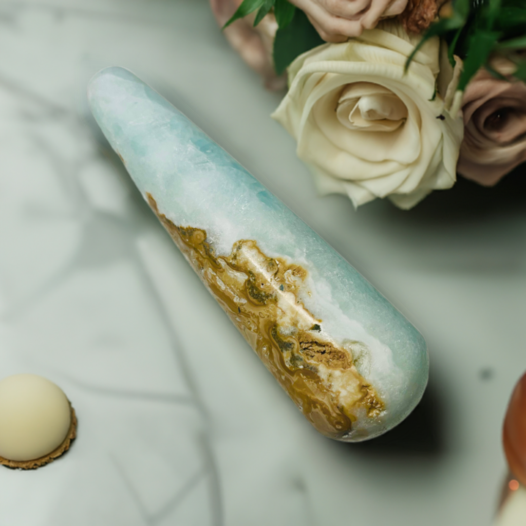 Caribbean Blue Calcite with a white rose behind it