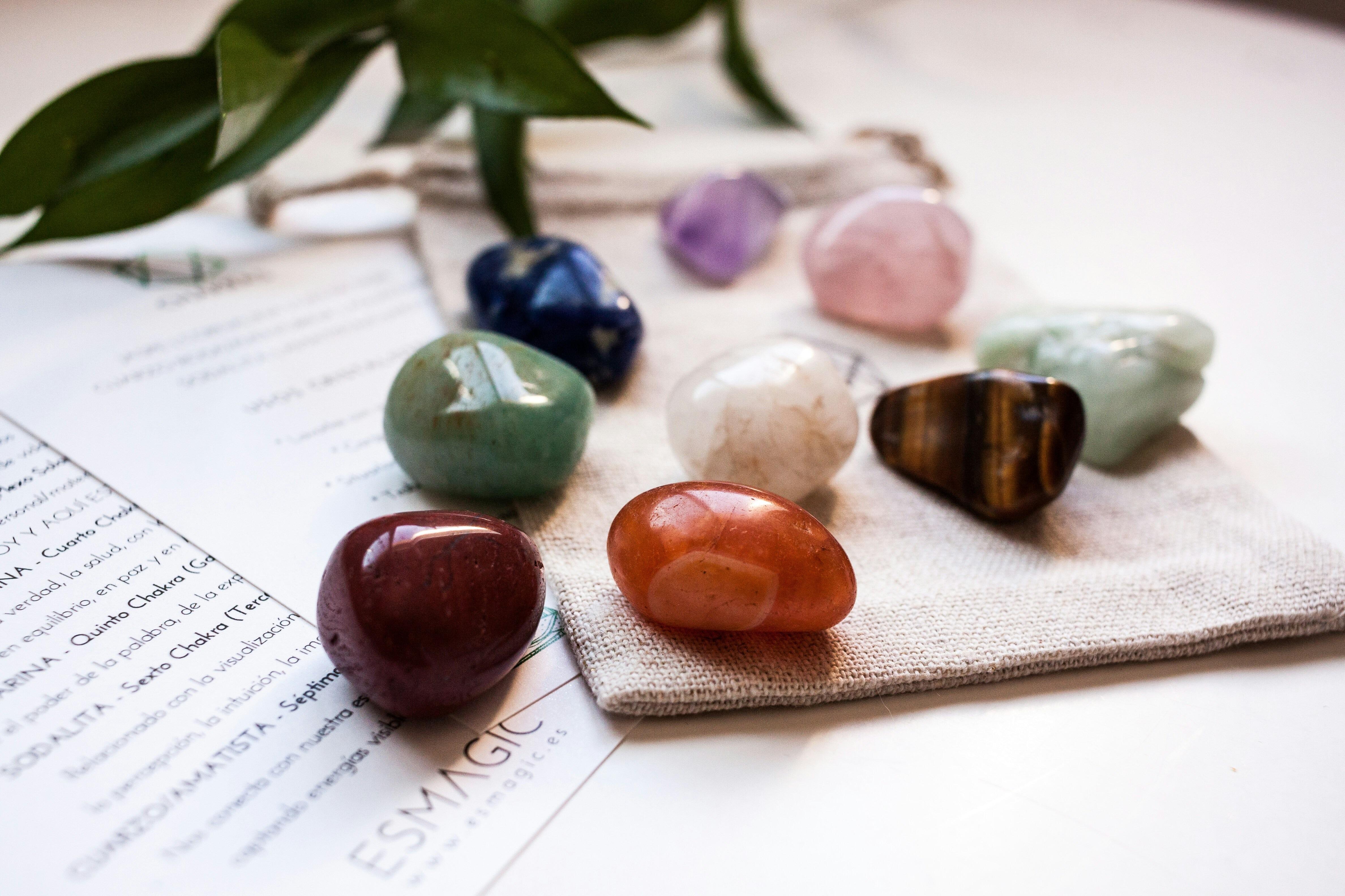 various different colour healing tumbled stones crystals scattered on a table