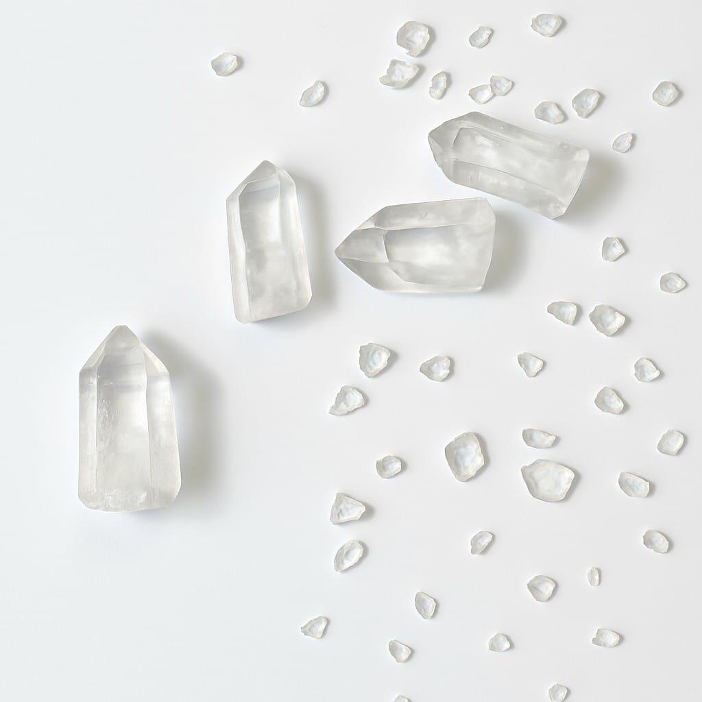 4 Lemurian Quartz on a table with clear Quartz crystals chips around them