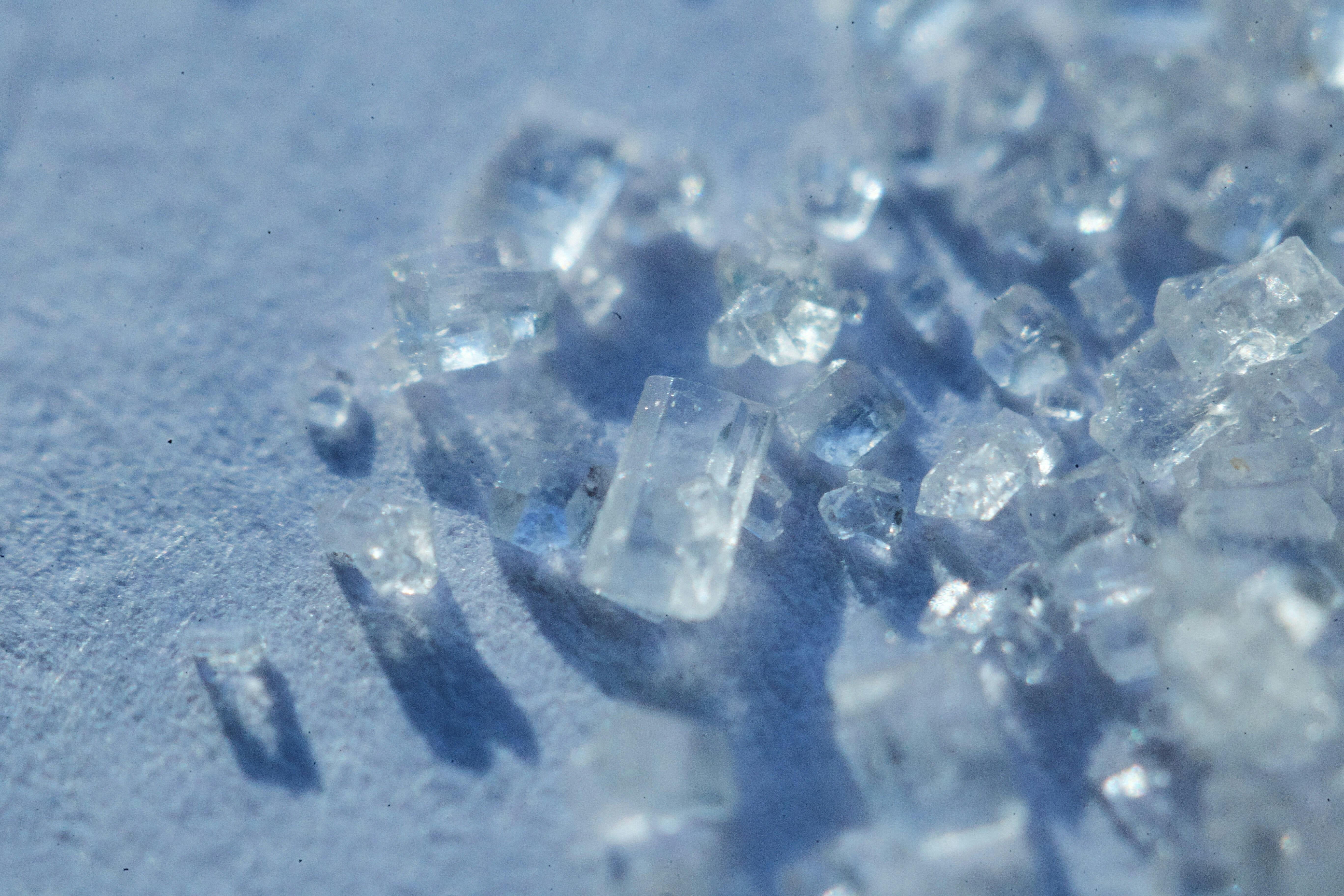 Clear Quartz crystal chips sprinkled on a blue table