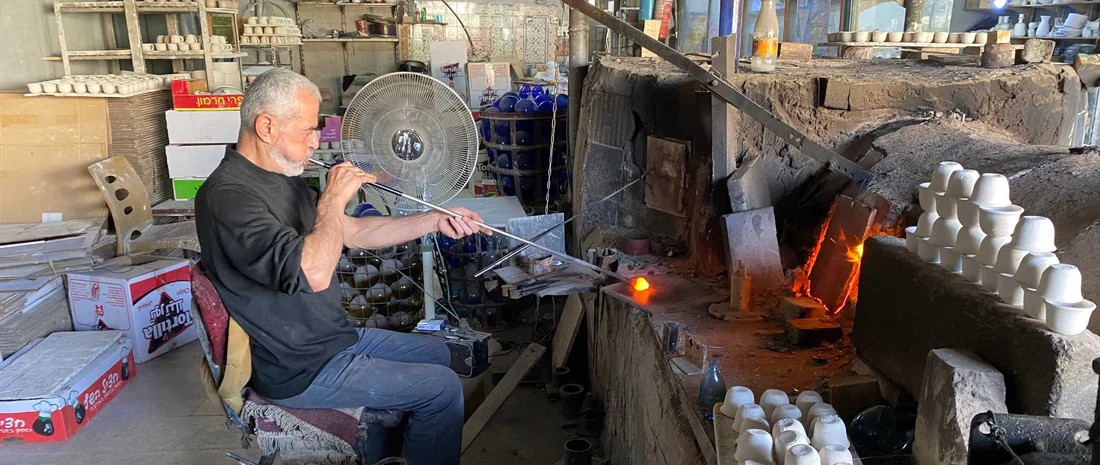 Mohammed blowing and shaping a glass bauble
