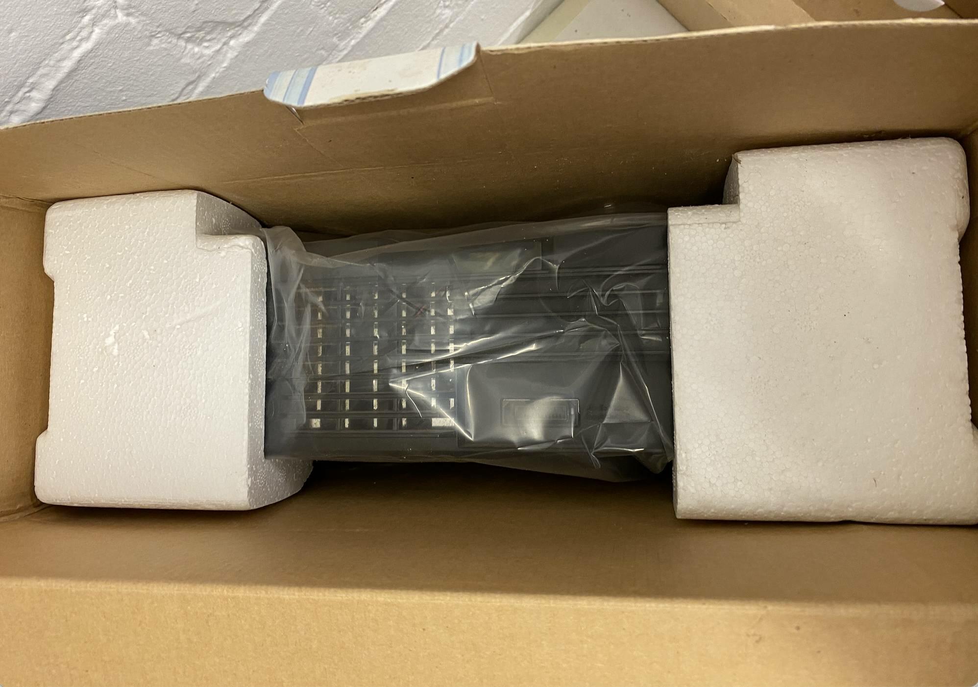 Interior of Crystal Xbox box showing black Xbox console nestled in original inserts.