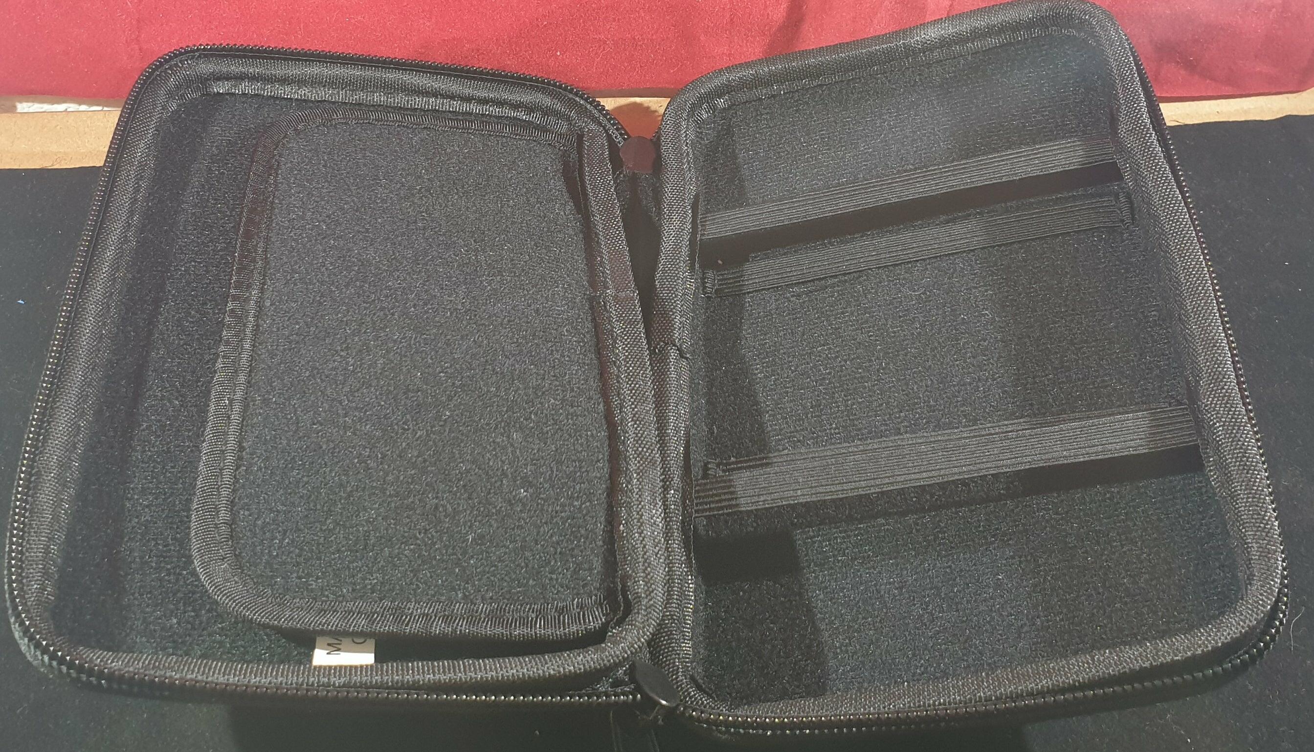 Open official Nintendo 3DS black case showing internal storage compartments for console and game cartridges – padded and protective design.