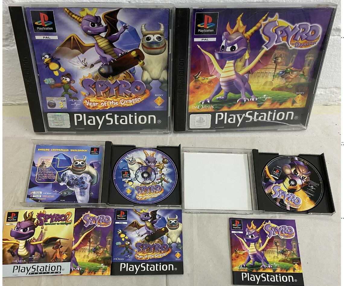 Two complete Spyro PlayStation 1 games with discs, manuals, and artwork laid out.