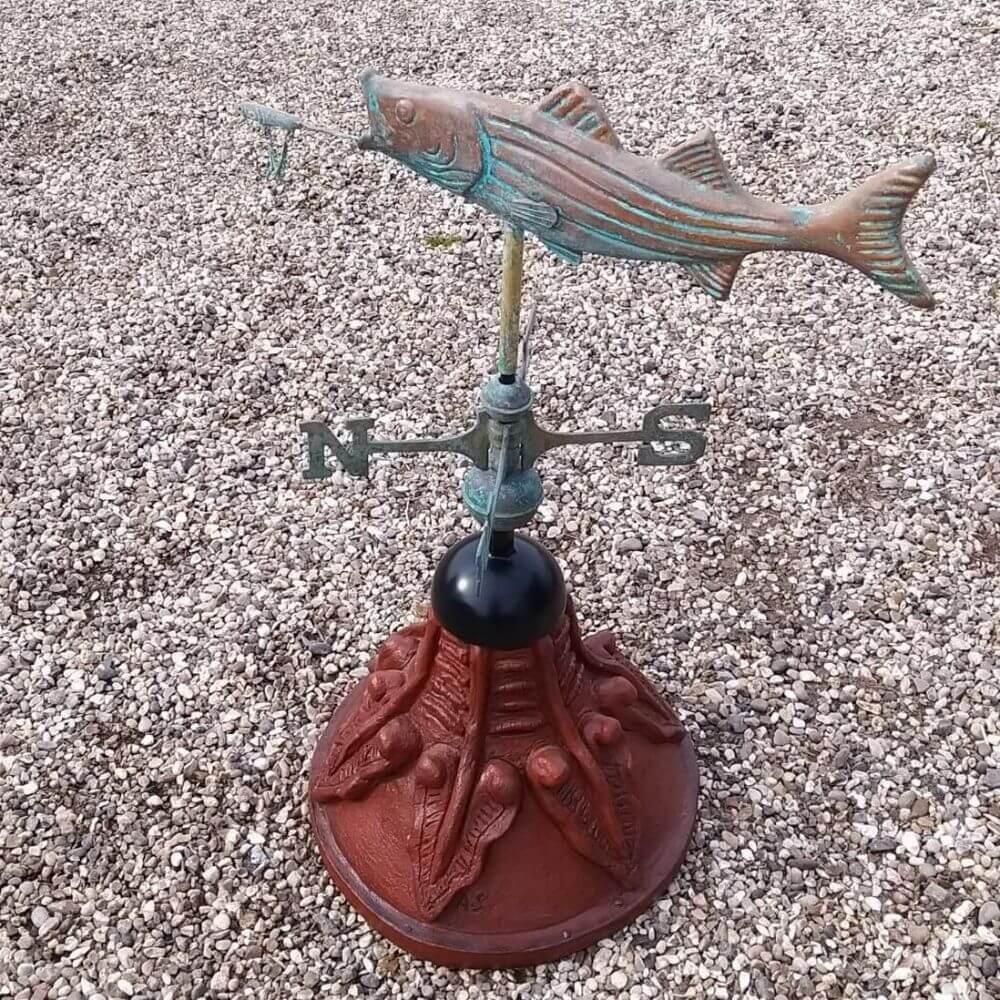 Fish weathervane fixed to a round ridge tile cap