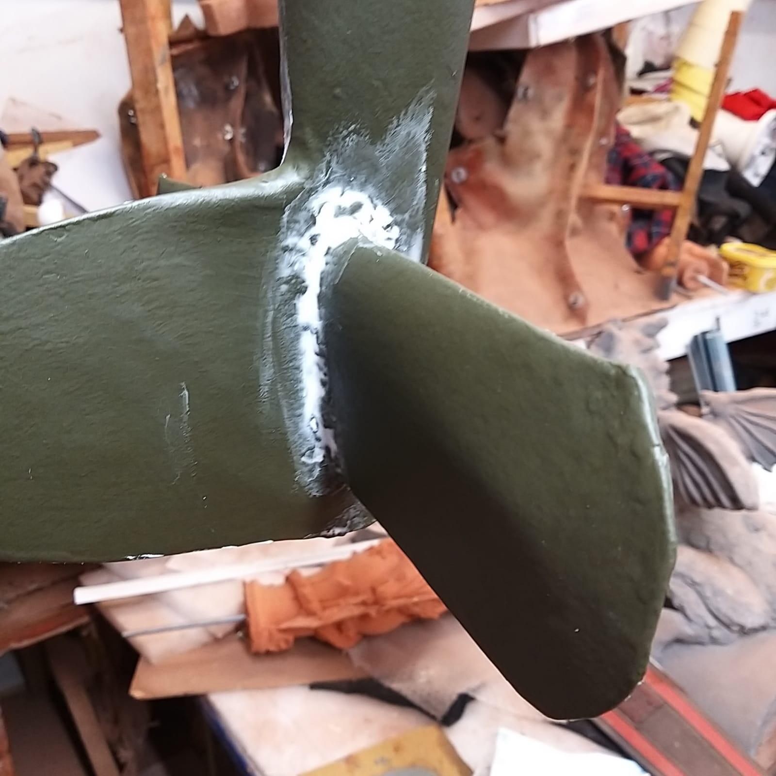 Spitfire weathervane tail section in the workshop being sanded and filled before repainting