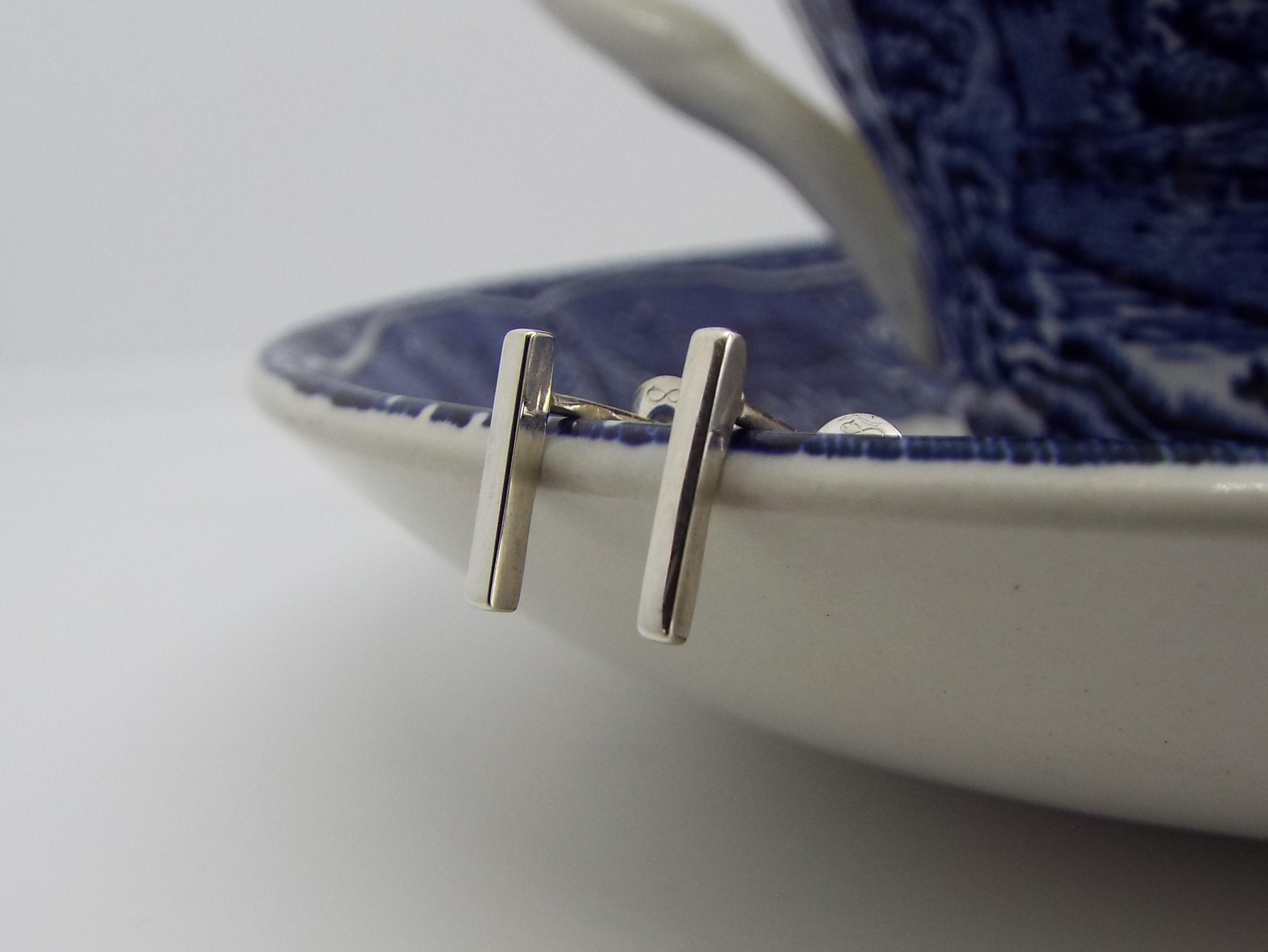 Silver bar Stud earrings on a blue saucer