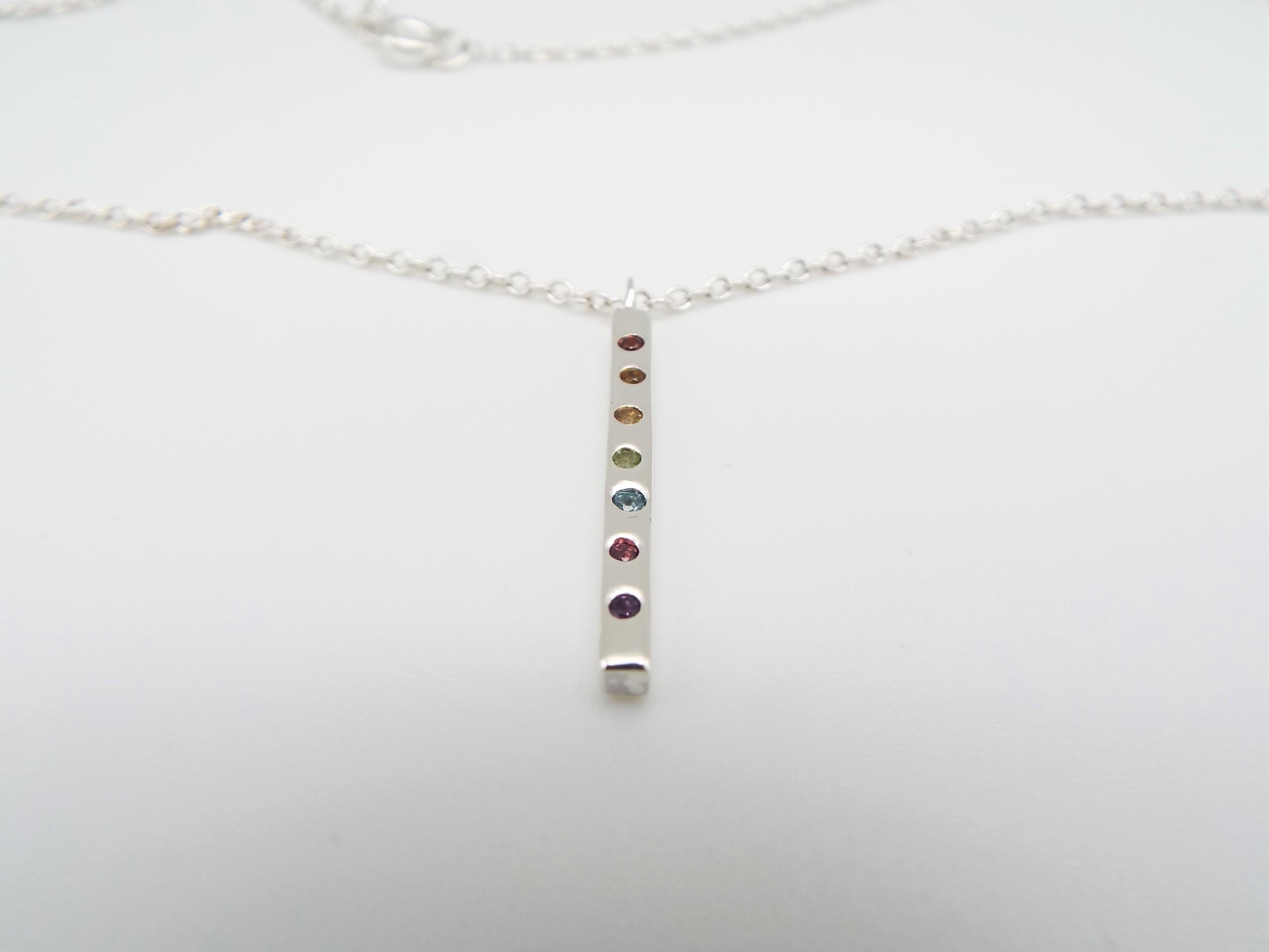 silver pendant with rainbow gemstones