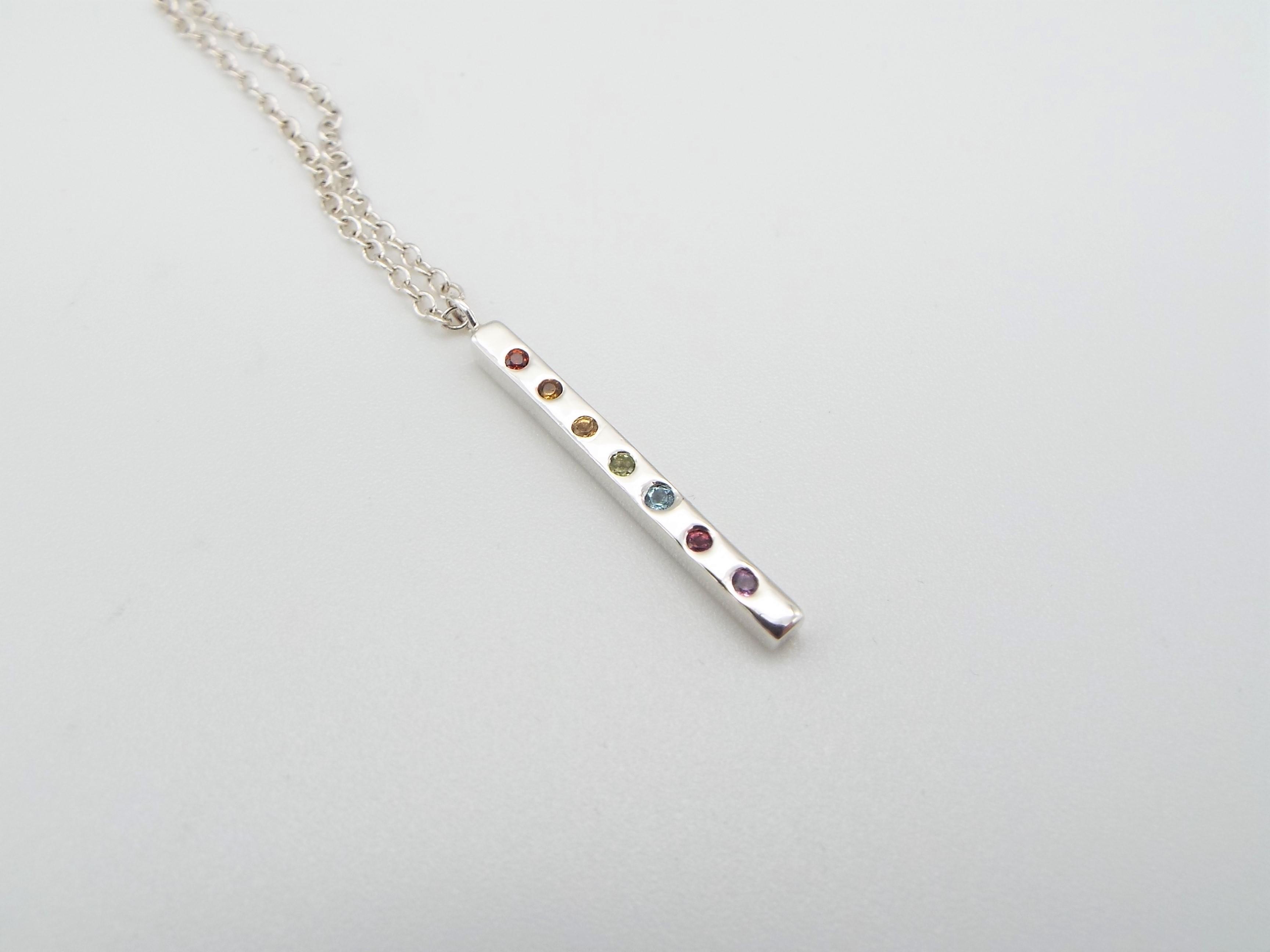 silver pendant set with rainbow gemstones