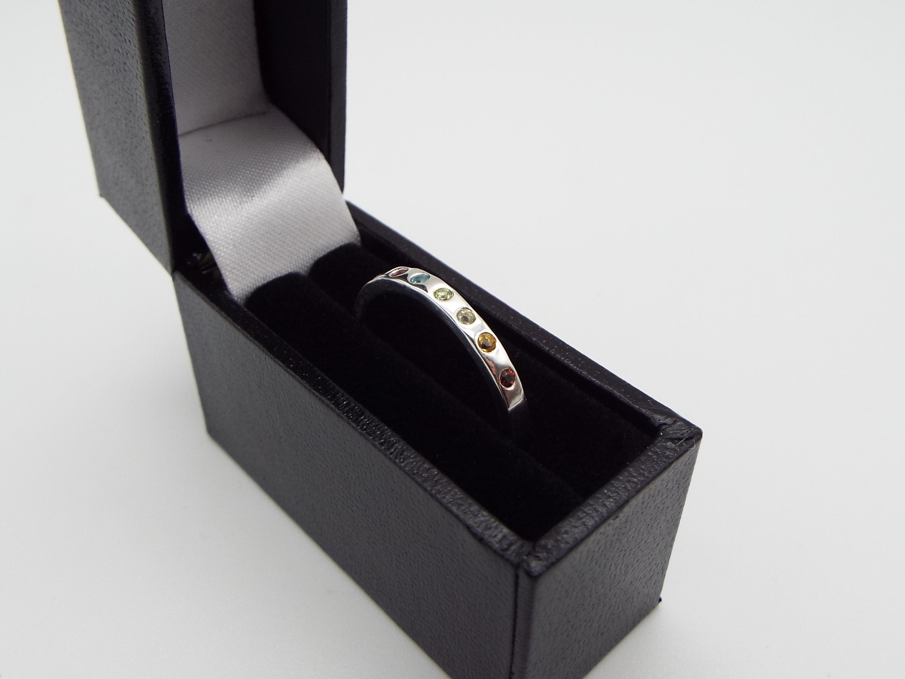 silver ring set with rainbow gemstones in a gift box