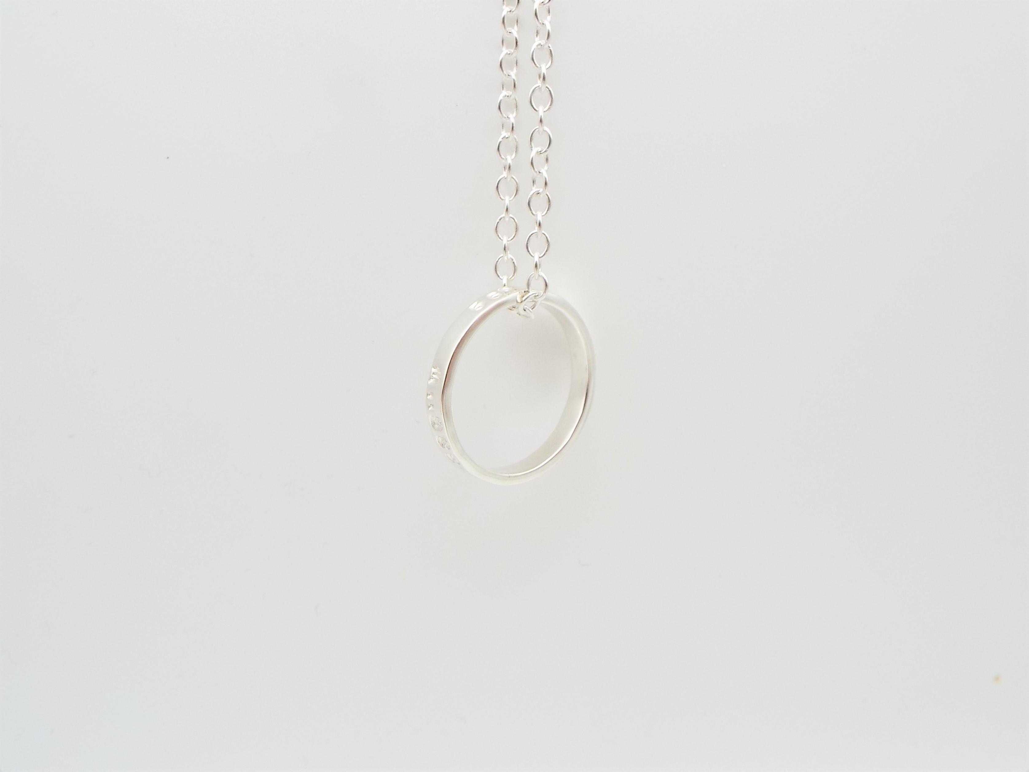 silver ring hanging on a silver chain