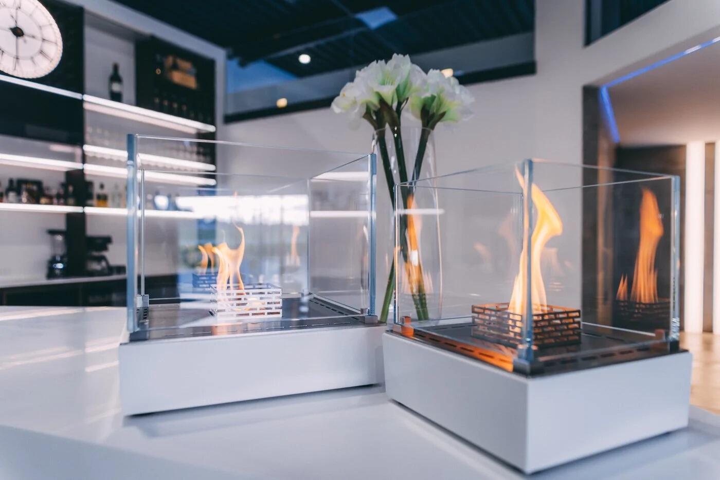 Pair of white Nice table-top fires on a counter