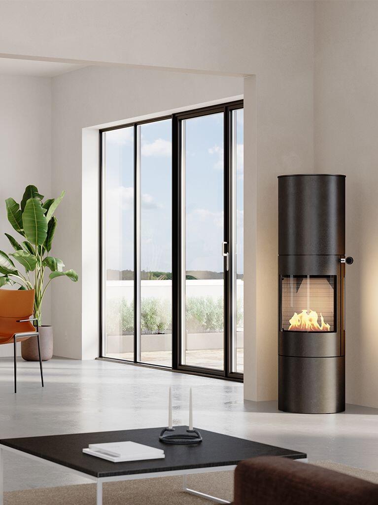 Rais Viva L 160 Bio tall bioethanol stove in black beside floor-to-ceiling windows