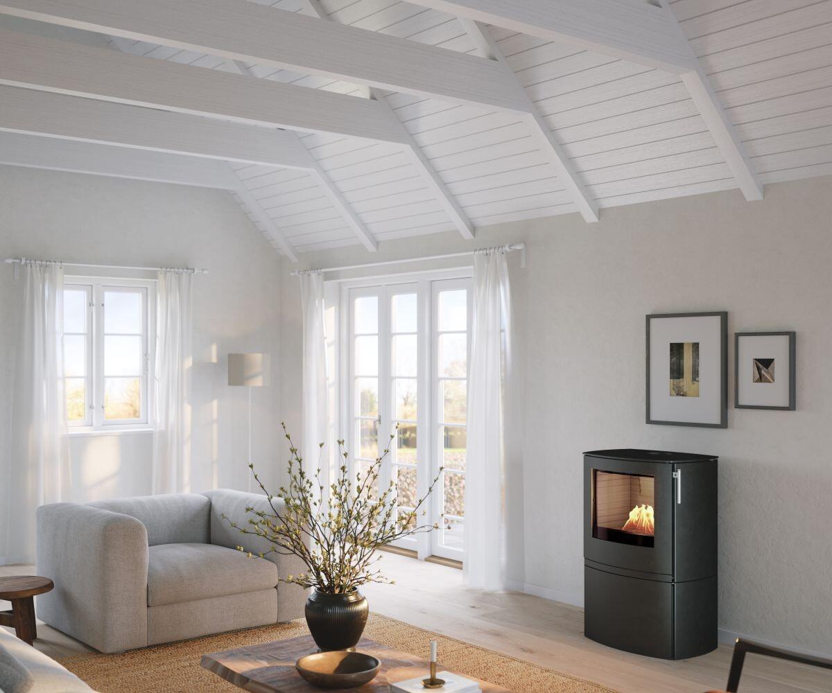 Rais Q-Tee 2 C Bio stove with curved front beside an armchair and coffee table