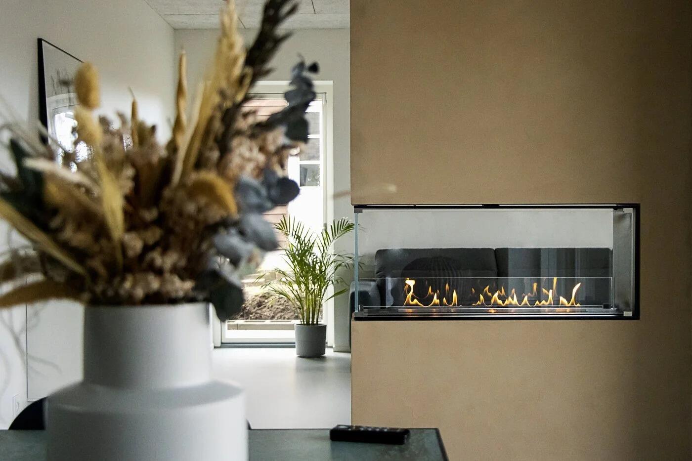 Montreal room divider fire in a brown wall behind dried flowers
